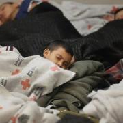 children sleeping in a holding cell